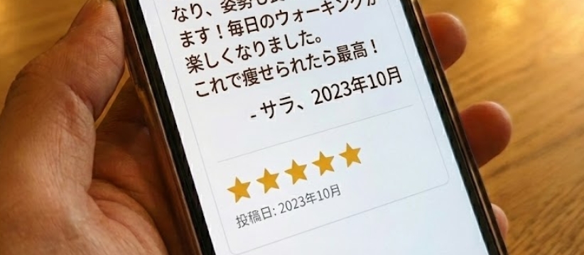 スマートフォンの画面に、ダイエットインソールに関する星5つの高評価レビューが表示されている様子。「足が疲れにくくなり、姿勢も良くなった気がします！」という具体的な感想と、投稿者名「サラ」、投稿日「2023年10月」が確認できる